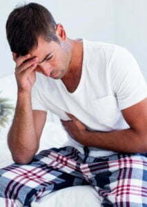 A man is sitting on a bed in a drug detox center