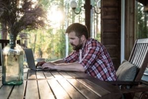 Man in red flannel sitting on computer