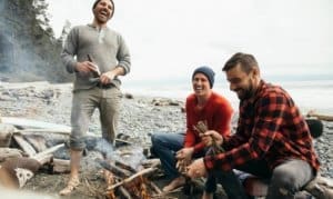 Three men sitting by a fire