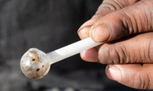 A person's hand holding a small piece of marijuana in an inpatient treatment facility.