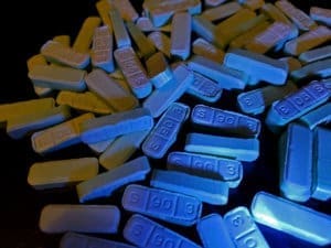 A pile of blue pills on a table in a drug detox center.