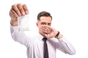 A man is holding a paper over his mouth in a drug detox center.