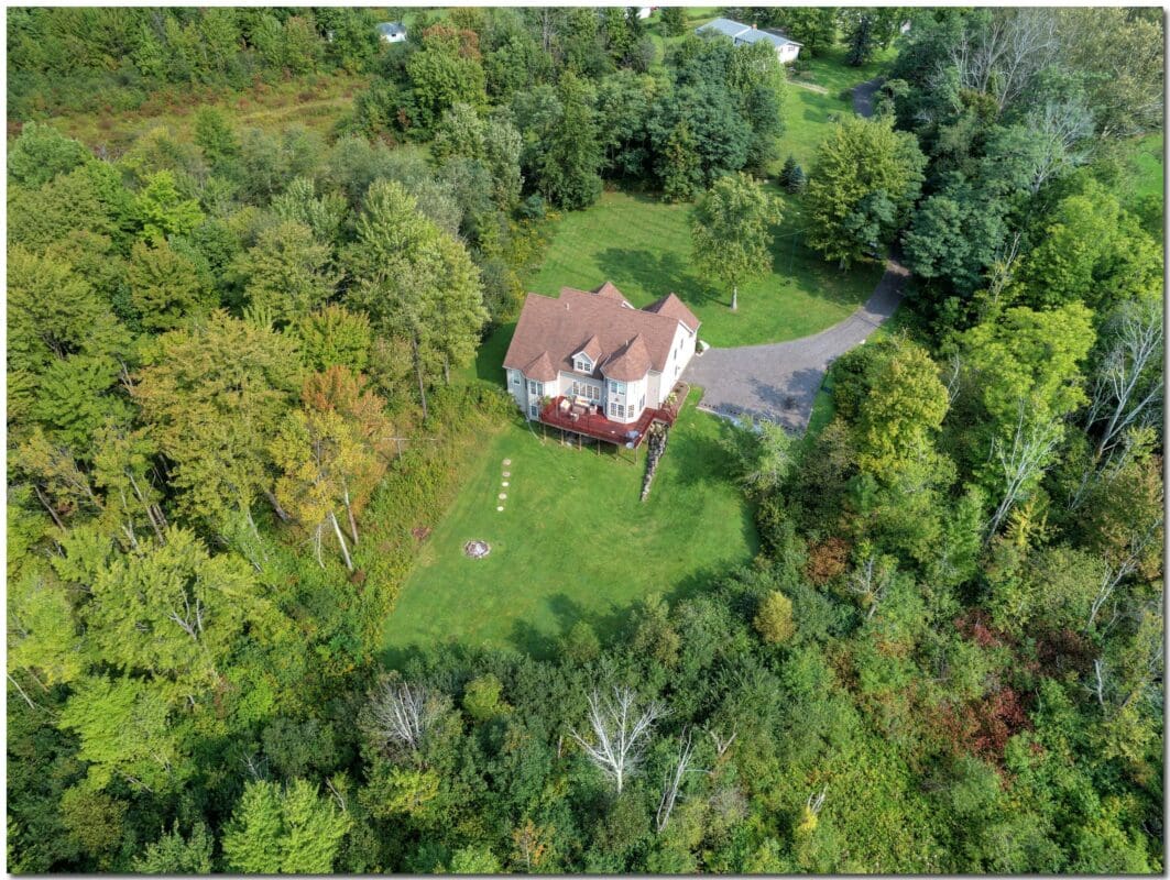 An aerial view of a house surrounded by trees.